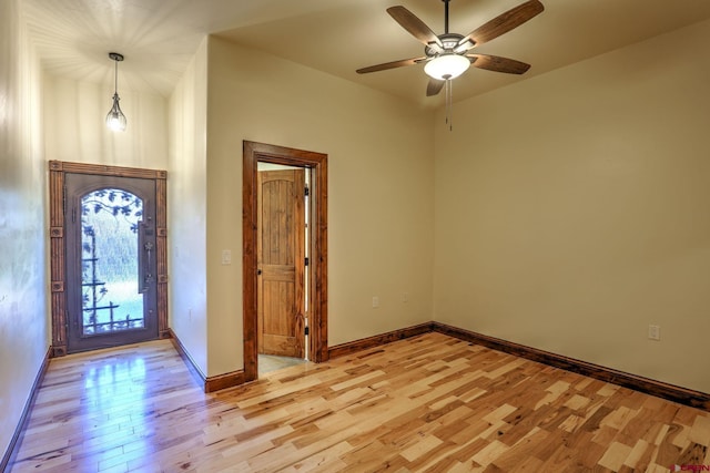 foyer featuring light wood-type flooring, a ceiling fan, and baseboards