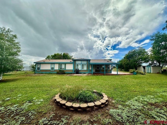 rear view of house featuring a storage unit, a lawn, and an outdoor structure