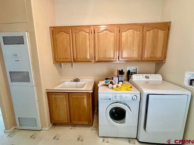 laundry area with independent washer and dryer, light tile patterned flooring, sink, and cabinets