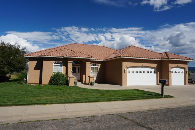 mediterranean / spanish house with a garage and a front yard