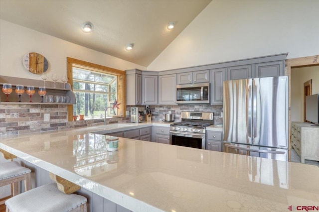 kitchen featuring sink, stainless steel appliances, tasteful backsplash, and gray cabinetry