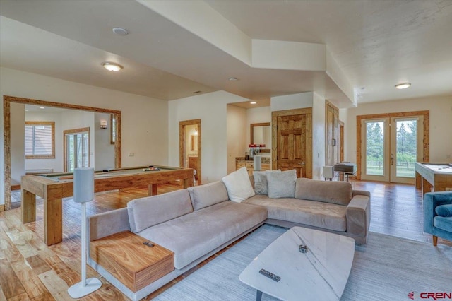 living room featuring light hardwood / wood-style flooring, french doors, and billiards