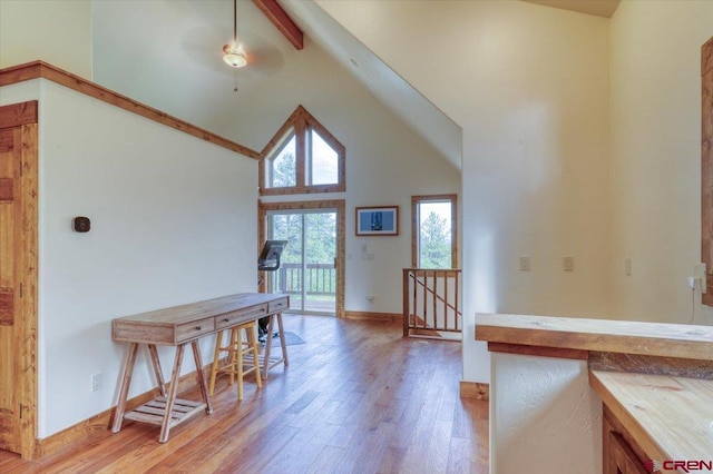 interior space with beamed ceiling, high vaulted ceiling, and hardwood / wood-style flooring