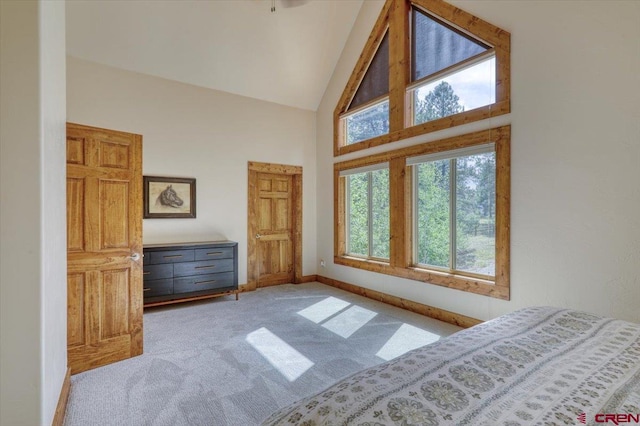 bedroom featuring high vaulted ceiling and light carpet