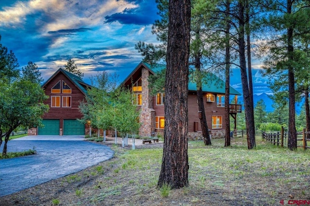 back house at dusk featuring a garage