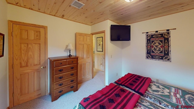 carpeted bedroom with wood ceiling