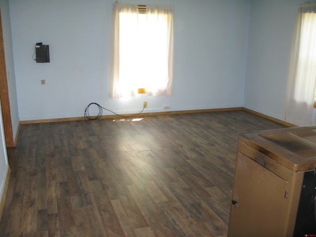 spare room with dark wood-style floors and baseboards