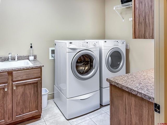 washroom featuring cabinets, washing machine and dryer, sink, and light tile patterned flooring