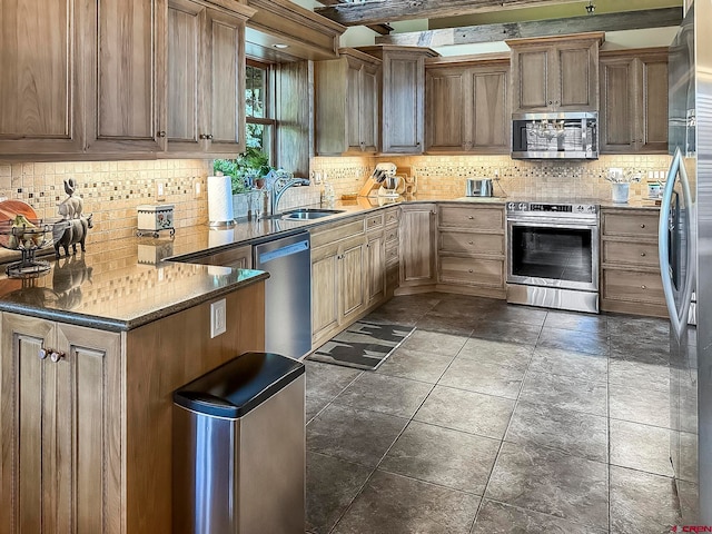 kitchen featuring appliances with stainless steel finishes, decorative backsplash, dark tile patterned floors, and beam ceiling