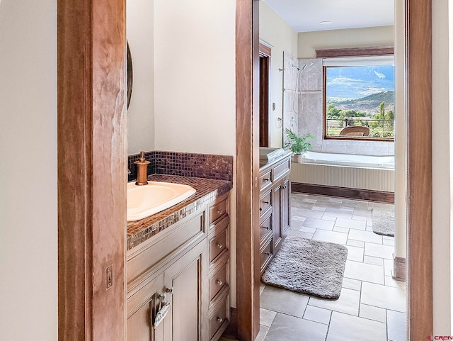 bathroom with vanity, a bath, and tile patterned floors