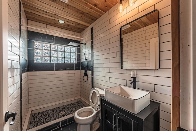 bathroom featuring tiled shower, vanity, toilet, and wooden ceiling