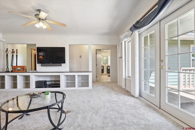 living area featuring a ceiling fan, carpet flooring, and french doors