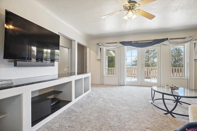 interior space featuring ceiling fan, a textured ceiling, carpet flooring, and french doors