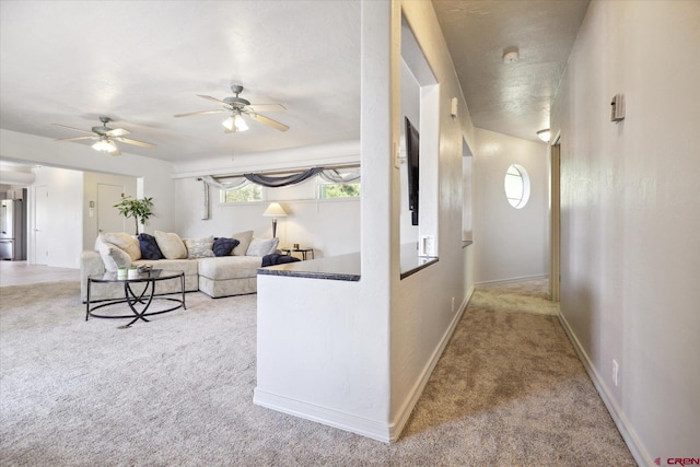 carpeted living room featuring ceiling fan and baseboards