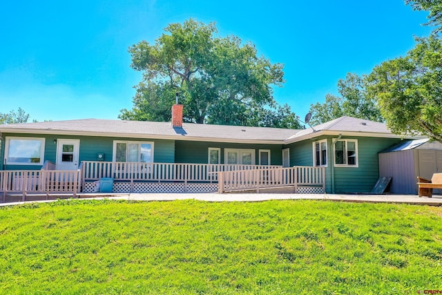 ranch-style home with a storage shed, a chimney, an outdoor structure, a porch, and a front yard