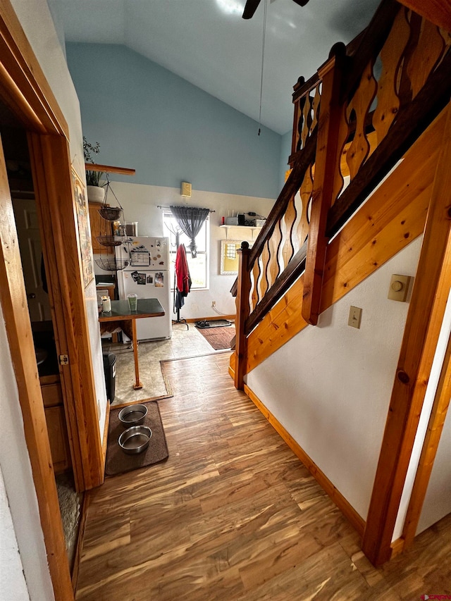 interior space featuring wood-type flooring, ceiling fan, and vaulted ceiling