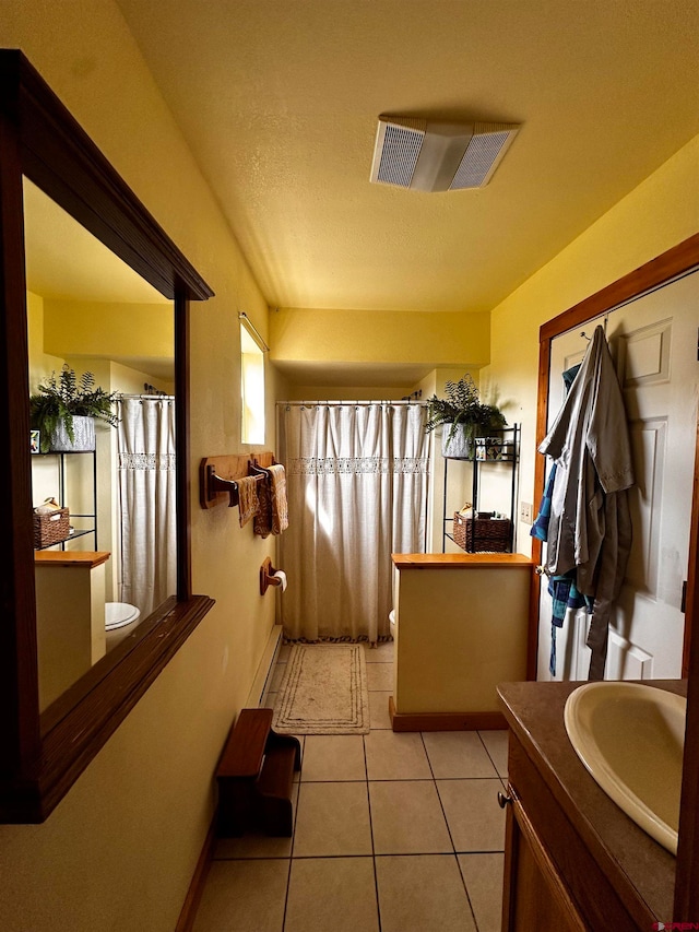 bathroom with tile patterned flooring, vanity, toilet, and a shower with curtain