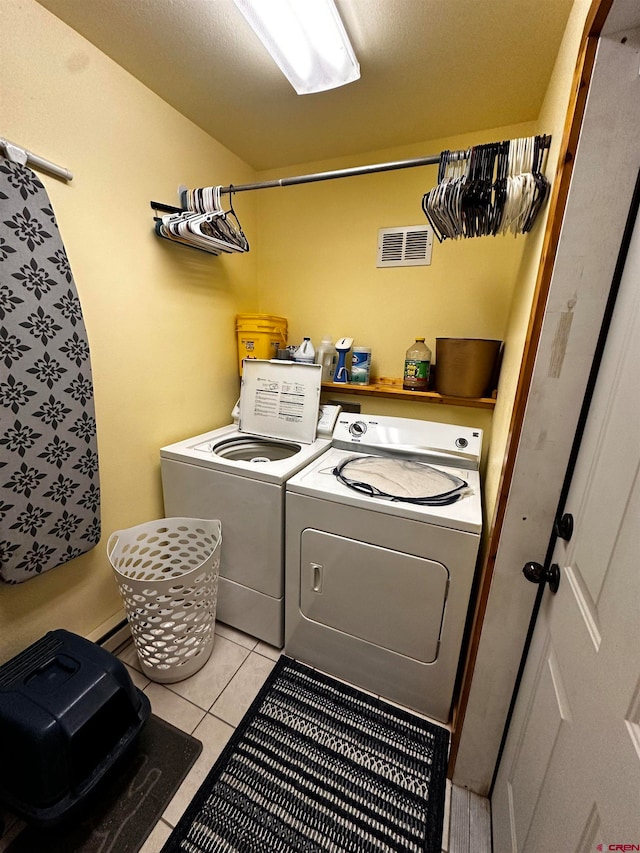 laundry area featuring washer and dryer and light tile patterned flooring