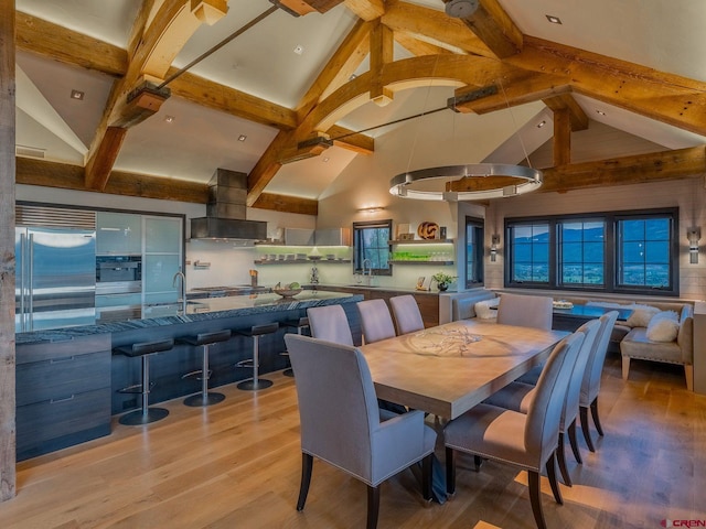 dining space featuring high vaulted ceiling, beam ceiling, and light hardwood / wood-style floors