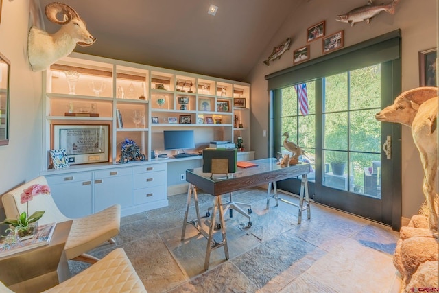 office featuring lofted ceiling and built in desk