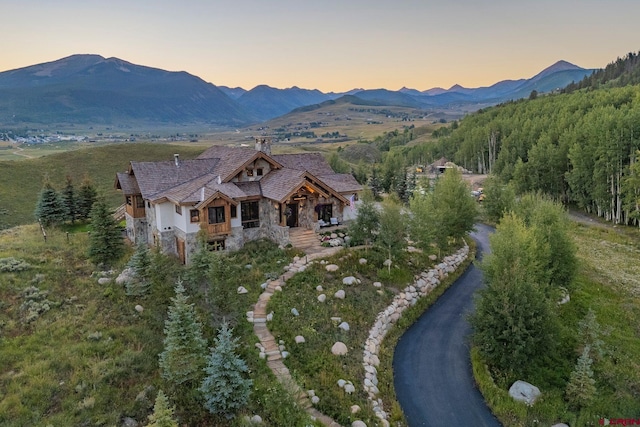 aerial view at dusk featuring a mountain view