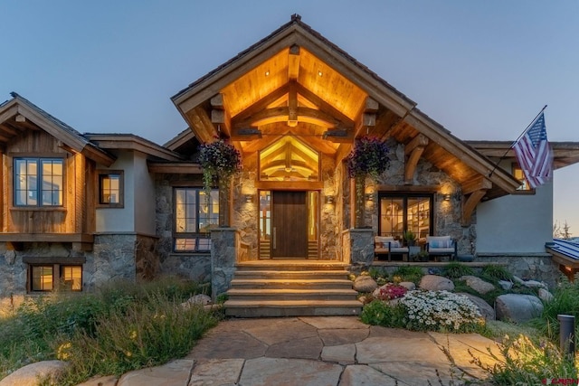 1251 Skyland Dr, Crested Butte, CO 81224 - view of front of property featuring stone siding, covered porch, and stucco siding