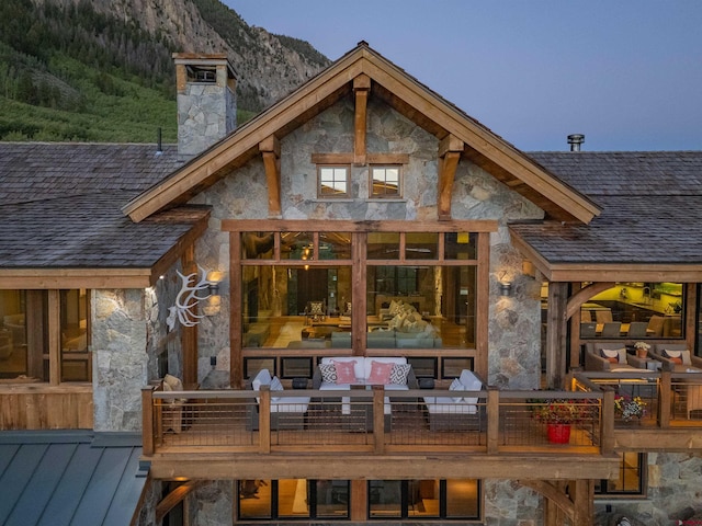 1251 Skyland Dr, Crested Butte, CO 81224 - rear view of house featuring a chimney, stone siding, and a deck with mountain view