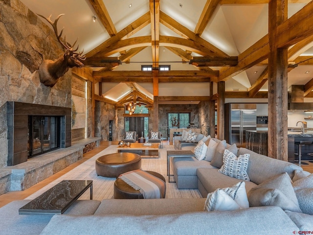 living room featuring high vaulted ceiling, beam ceiling, a chandelier, and a fireplace