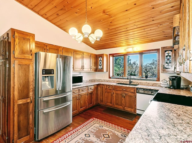 kitchen with hanging light fixtures, stainless steel appliances, a notable chandelier, sink, and lofted ceiling