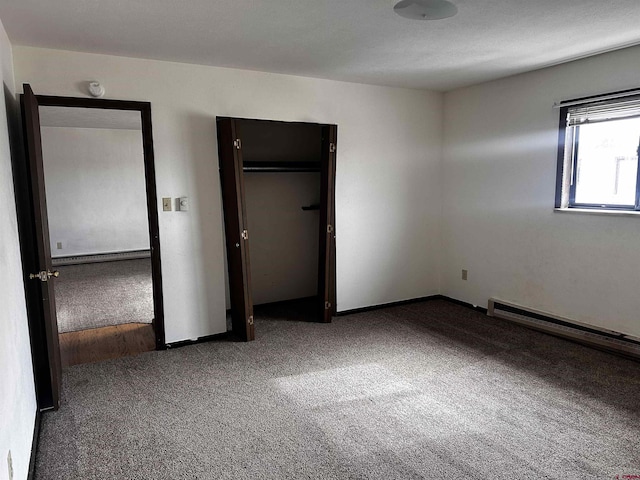 304 N 9th St Unit 5A, Gunnison, CO 81230 - unfurnished bedroom featuring a baseboard heating unit, baseboards, a closet, carpet, and a baseboard radiator