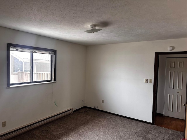 carpeted empty room featuring baseboard heating and a textured ceiling