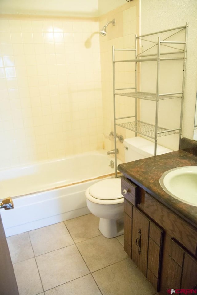 full bathroom featuring toilet, tiled shower / bath, tile patterned floors, and vanity