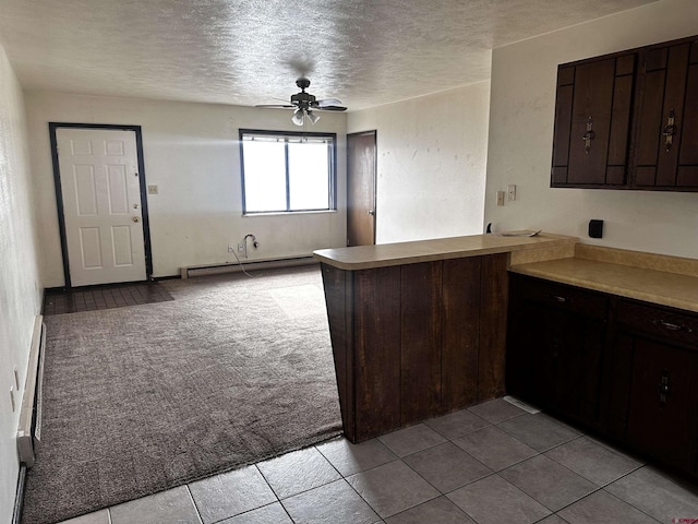 304 N 9th St Unit 5A, Gunnison, CO 81230 - kitchen with ceiling fan, dark brown cabinetry, a peninsula, a textured ceiling, and a baseboard heating unit