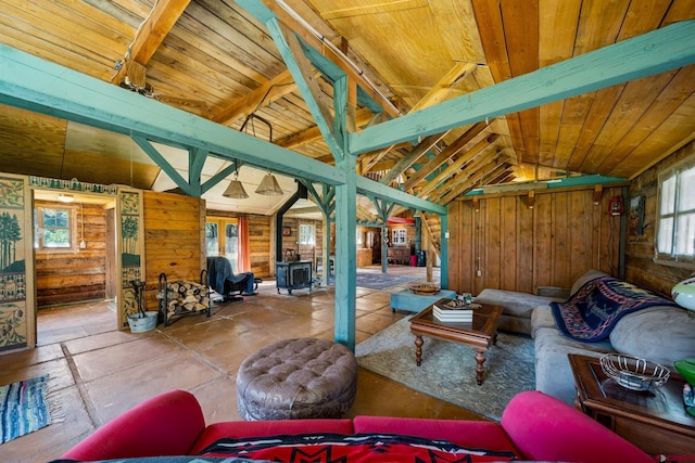 living room with wood walls, wooden ceiling, and vaulted ceiling with beams