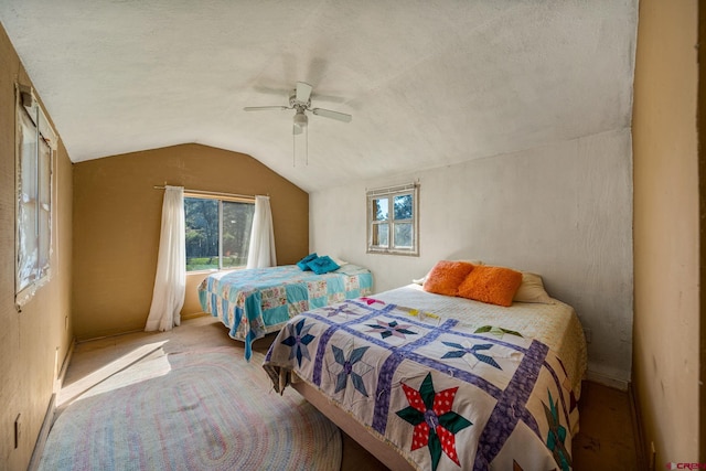 bedroom featuring lofted ceiling, ceiling fan, carpet floors, and a textured ceiling