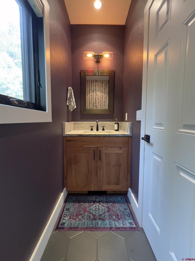 bathroom with tile patterned flooring, vanity, and baseboards