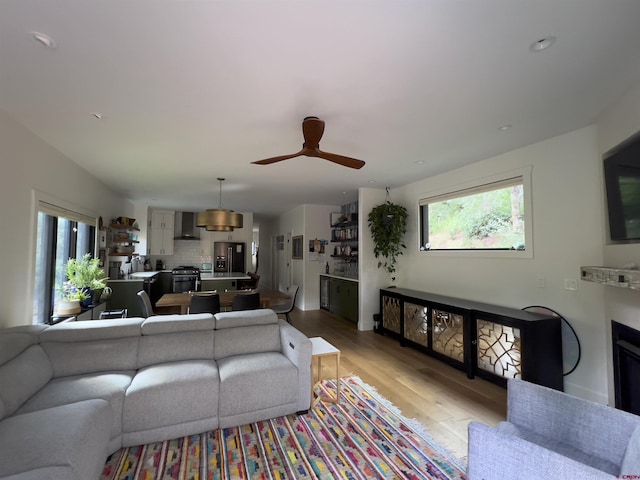 living room featuring light wood-style flooring and ceiling fan