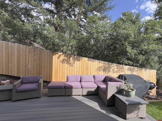 wooden deck with grilling area, outdoor lounge area, and fence