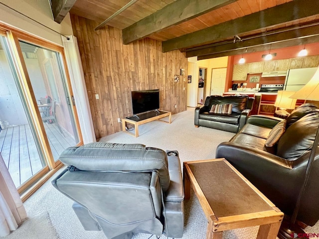 carpeted living room with beam ceiling, wooden ceiling, and wooden walls