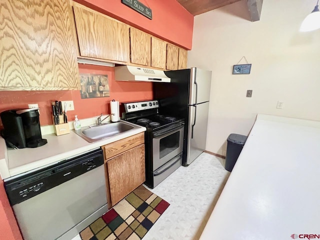kitchen with a sink, light countertops, stainless steel appliances, light floors, and under cabinet range hood