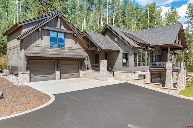 craftsman house featuring a garage, a balcony, and central AC