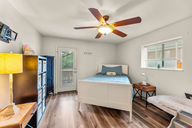 bedroom with access to exterior, ceiling fan, and dark hardwood / wood-style floors