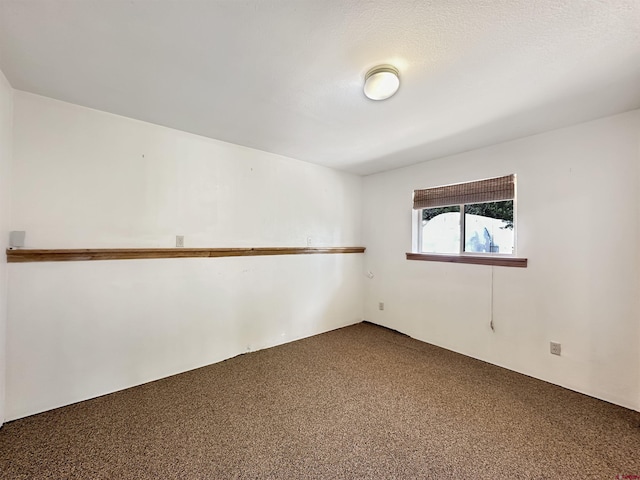 unfurnished room featuring dark colored carpet