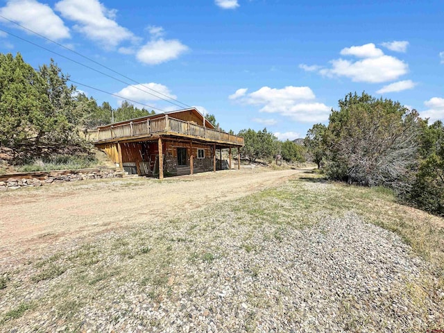 view of yard with driveway and a deck