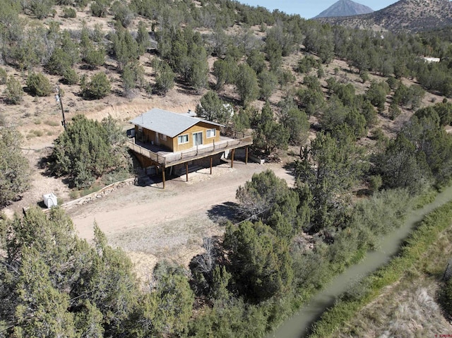 birds eye view of property featuring a mountain view and a view of trees