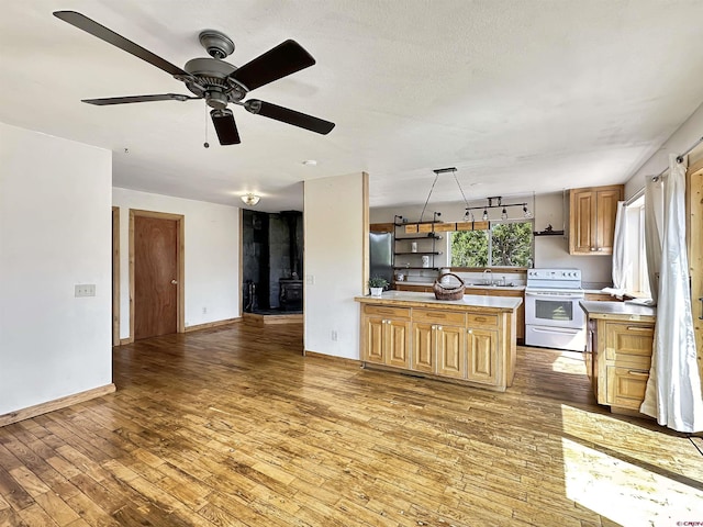 kitchen with light countertops, white electric range, light wood-style flooring, open floor plan, and stainless steel fridge