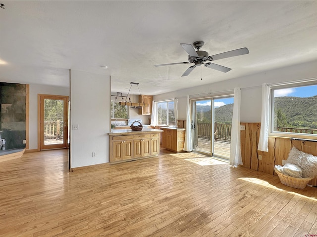 unfurnished living room featuring ceiling fan and light wood-style floors