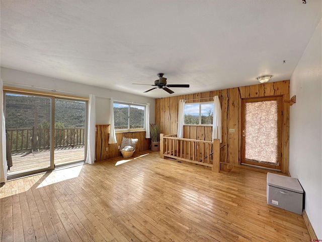 interior space featuring a wealth of natural light, wooden walls, and hardwood / wood-style floors