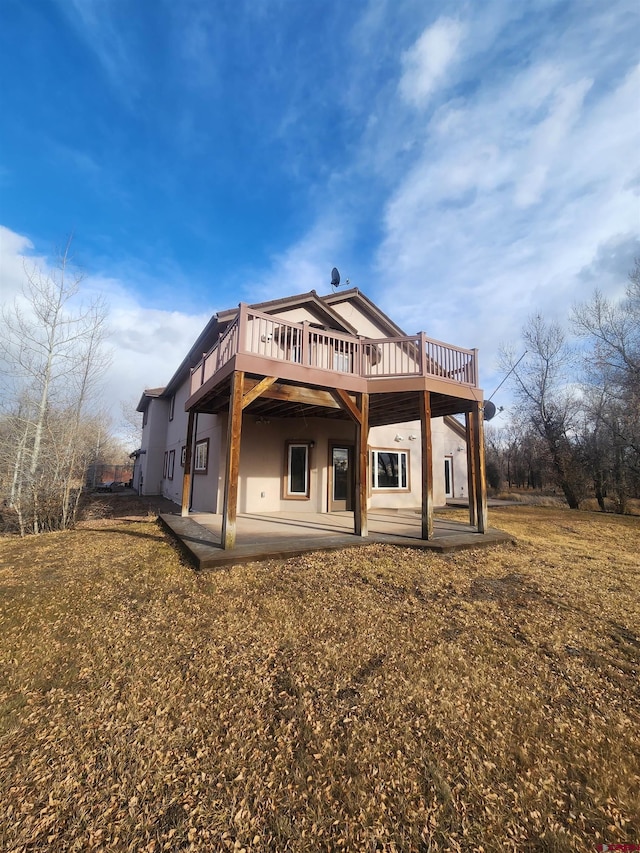 rear view of house with a yard, a patio, and a deck