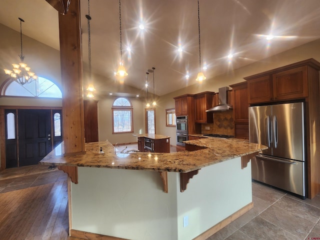 kitchen with pendant lighting, light hardwood / wood-style flooring, an inviting chandelier, wall chimney exhaust hood, and appliances with stainless steel finishes